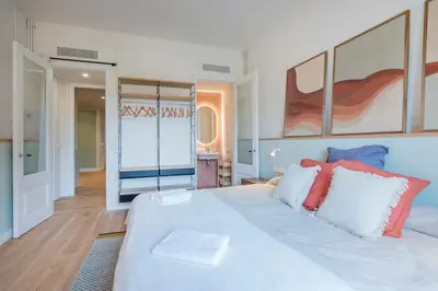 a bedroom with a large white bed with paintings on the wall at The Collection Barcelona - Exclusive Paseo de Gracia 5BD 5BTH with terrace in Barcelona