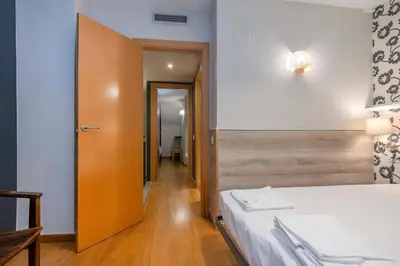 a bedroom with a white bed with a black and white wall at The Collection Barcelona - Bright and modern Duplex with terrace in Eixample district P1 in Barcelona