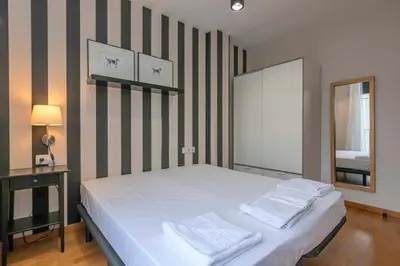 a bedroom with a large white bed with a mirror at The Collection Barcelona - Modern and bright apartment in Eixample 5-1 in Barcelona