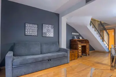 a living room with a couch and a staircase at The Collection Barcelona - Bright and modern Duplex with terrace in Eixample district P2 in Barcelona