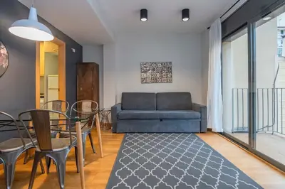 a living room with a couch and a table and chairs at The Collection Barcelona - 2 bedroom with balcony in Eixample 1-1 in Barcelona