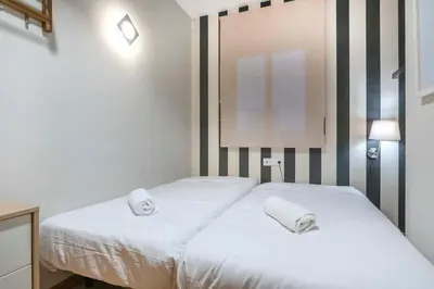 a bedroom with two beds with towels on them at The Collection Barcelona - 2 bedroom with balcony in Eixample 3-2 in Barcelona