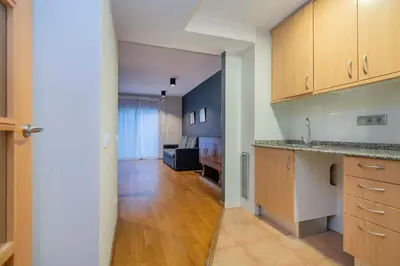 a kitchen with wooden cabinets and a long hallway at The Collection Barcelona - 2 bedroom with balcony in Eixample 3-2 in Barcelona