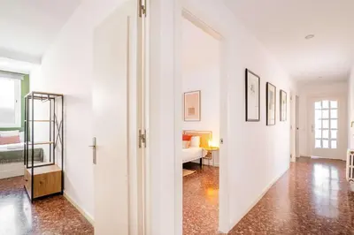 a white hallway with a bed and a room at The Collection Barcelona - Big apartment for 15 in the heart of Eixample in Barcelona