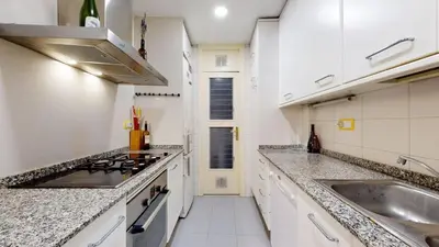 a white kitchen with a sink and a stove at The Collection Barcelona - Modern and bright three-bedroom in Eixample in Barcelona