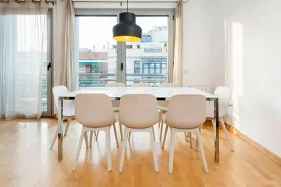 a dining room with a white table and chairs at The Collection Barcelona - Spacious and Elegant 4 Bedroom with Private Terrace in Barcelona