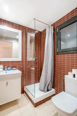 a bathroom with a shower and a toilet and a sink at The Collection Barcelona - Pl Universitat Comfortable 3BD with private patio in Barcelona