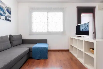 a living room with a couch and a tv at The Collection Barcelona - Sunny Atico with Terrace in Pl Universitat! in Barcelona