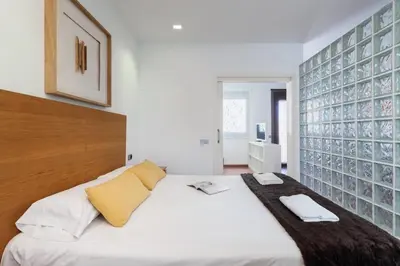 a bedroom with a white bed with a wooden headboard at The Collection Barcelona - Sunny Atico with Terrace in Pl Universitat! in Barcelona