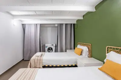 two beds in a room with green walls at The Collection Barcelona - Modern and bright 4BD triplex in Paralel! in Barcelona