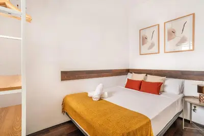a bedroom with a bed with orange and white pillows at The Collection Barcelona - 4- Bedroom Apartment in Gracia Village in Barcelona