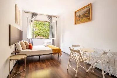 a living room with a table and chairs and a window at The Collection Barcelona - 4- Bedroom Apartment in Gracia Village in Barcelona