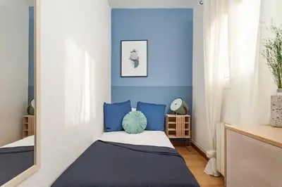 a bedroom with blue walls and a bed with blue pillows at The Collection Barcelona - City View Penthouse - 2 Bedroom Suite in Barcelona