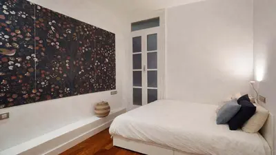 a bedroom with a bed and a large painting on the wall at The Collection Barcelona - Classy 3BD - 2BTH with private patio in Eixample in Barcelona