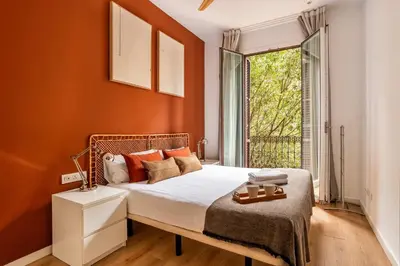 a bedroom with a bed with orange walls and a window at The Collection Barcelona - Beautiful 4bd 4ba apartment in Eixample District in Barcelona