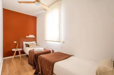a small bedroom with two beds and a window at The Collection Barcelona - Beautiful 4bd 4ba apartment in Eixample District in Barcelona