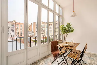 a dining room with a table and chairs and windows at The Collection Barcelona - Very Spacious Eixample 4bd 4ba apartment in Barcelona
