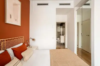 a bedroom with a bed with orange walls and a mirror at The Collection Barcelona - Very Spacious Eixample 4bd 4ba apartment in Barcelona