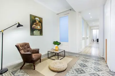 a living room with a chair and a table at The Collection Barcelona - 4bedroom apart with balcony in Las Ramblas 1 1 in Barcelona