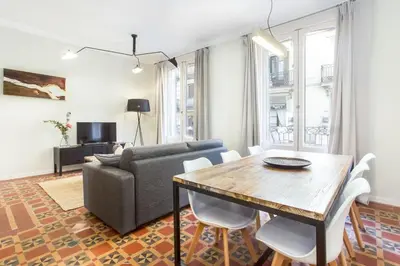 a white bedroom with two beds and a mirror at The Collection Barcelona - 4bedroom apartment with a balcony in Las Ramblas 1 2 in Barcelona