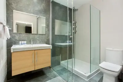 a bedroom with a bed and a chair in it at The Collection Barcelona - Centric 3bedroom in Las Ramblas 2 1B in Barcelona