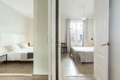 a hotel room with two beds and a hallway at The Collection Barcelona - 4bedroom apart with balcony in Las Ramblas 3-2 in Barcelona