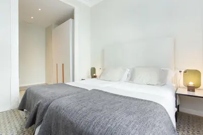 a bedroom with a large white bed and a desk at The Collection Barcelona - 4bedroom apart with balcony in Las Ramblas 3-2 in Barcelona