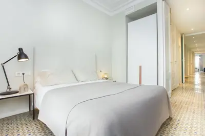 a white bedroom with a white bed and a lamp at The Collection Barcelona - 4bedroom apart with balcony in Las Ramblas 3-2 in Barcelona