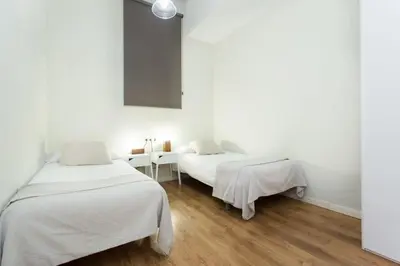 a white bedroom with a white bed and a lamp at The Collection Barcelona - Bright and modern 4bedroom with terrace in Las Ramblas P1 in Barcelona