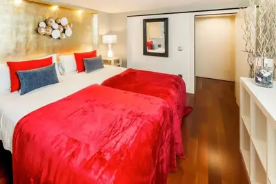 a bedroom with a large bed with a red blanket at The Collection Barcelona - Luxury Duplex Apartment in the Heart of Barcelona in Barcelona