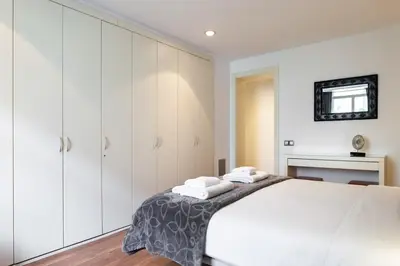 a white kitchen with white cabinets and a sink at The Collection Barcelona - Plaça Catalunya 3bedroom Duplex with Balcony in Barcelona