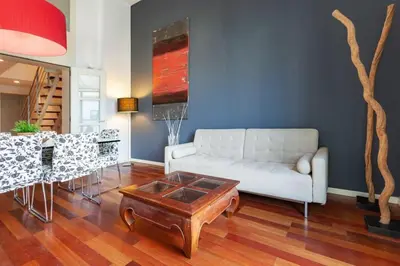 a living room with white cabinets and a table at The Collection Barcelona - 3bedroom Duplex with balcony in plaza Cataluña in Barcelona