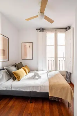a living room with a couch and a television at The Collection Barcelona - Plaza Urquinaona 3-Bedroom Suite in Barcelona