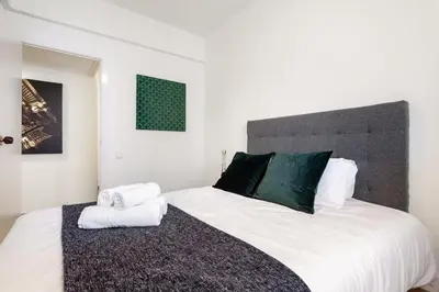 a quotationatory logo with a magnifying glass at The Collection Barcelona - Exclusive Huge 4 Double Bedroom City Center in Barcelona