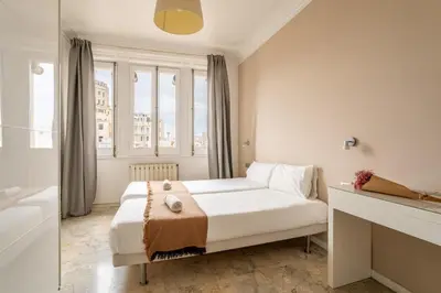 a white bedroom with a bed and a window at The Collection Barcelona - Placa Catalunya Luminous and Exclusive 5Bd Penthouse in Barcelona