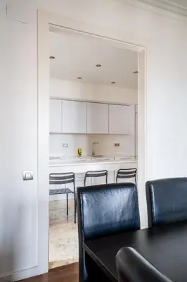 a dining room with a table and chairs and a kitchen at The Collection Barcelona - Placa Catalunya Luminous and Exclusive 5Bd Penthouse in Barcelona