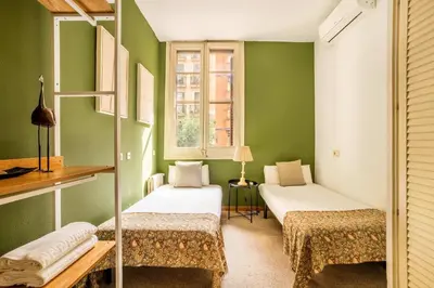 two beds in a room with green walls at The Collection Barcelona - Huge historic 5BD with private Terrace! in Barcelona