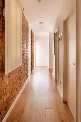 a corridor with a brick wall and a hallway with at The Collection Barcelona - Perfectly located 4bed 4bath apartment in Eixample in Barcelona