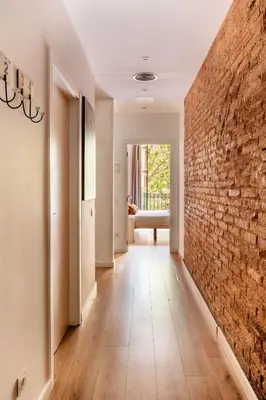 a hallway with a brick wall and a hallway with a chair at The Collection Barcelona - Perfectly located 4bed 4bath apartment in Eixample in Barcelona