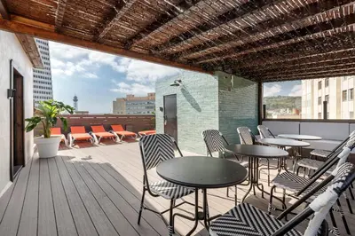 a patio with tables and chairs on a balcony at Stay U-nique Apartments Est in Barcelona