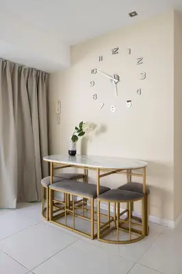 a table with two chairs and a clock on the wall at PLAYA a 3 minutos Parking barbacoa Apartamento en Castelldefels in Castelldefels