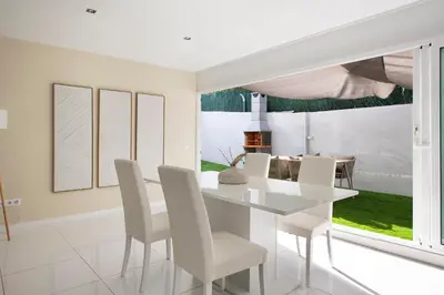 a white dining room with a white table and chairs at PLAYA a 3 minutos Parking barbacoa Apartamento en Castelldefels in Castelldefels