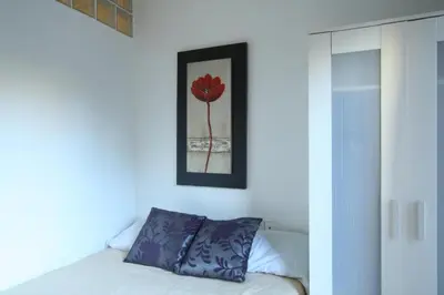 a bedroom with a bed with a red flower on the wall at GOOD APARTMENTS gran via 3 bedrooms in Barcelona