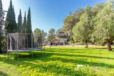 a swimming pool in front of a house at Spacious Villa Santa Fe - private pool, big garden and A/C close to Sitges in Olivella