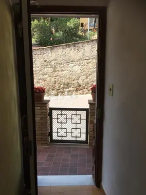 an open door to a courtyard with a stone wall at Casa iaia in Monistrol