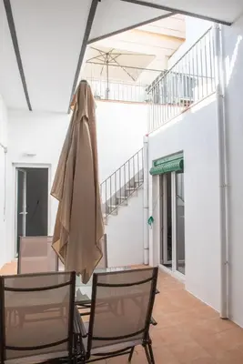 a room with two chairs and a table with a umbrella at Hauzify I Apartament Can Missé in Calella