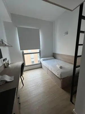 a small room with two bunk beds and a window at Micampus Barcelona Student Residence in Barcelona