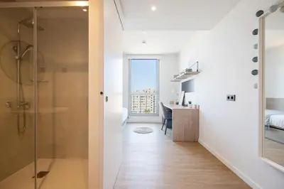 a bathroom with a shower and a desk in a room at Micampus Barcelona Student Residence in Barcelona