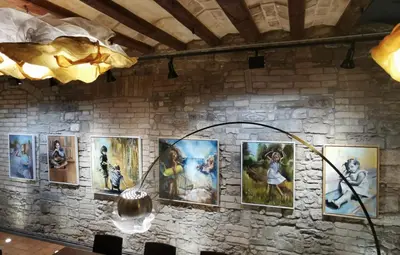 a wall full of paintings on a brick wall at Habitació polivalent al centre de Manresa in Manresa