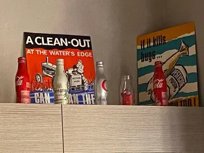 a collection of soda bottles on top of a cabinet at Habitació polivalent al centre de Manresa in Manresa